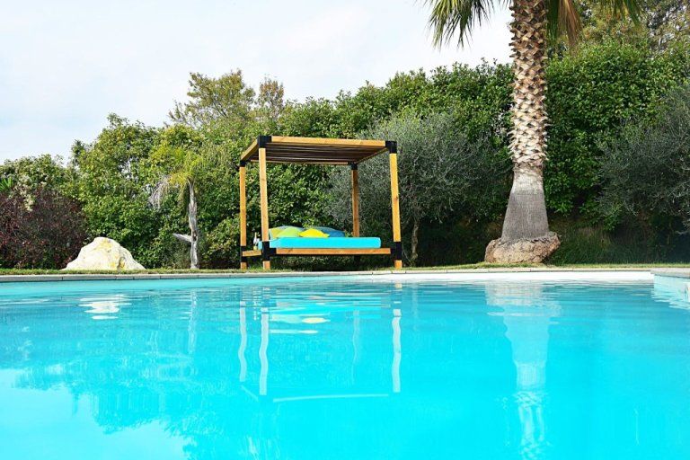 La piscine privée et le lit balinais, entre palmiers et oliviers