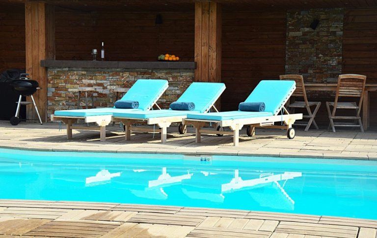 Transats au bord de la piscine, devant le pool house