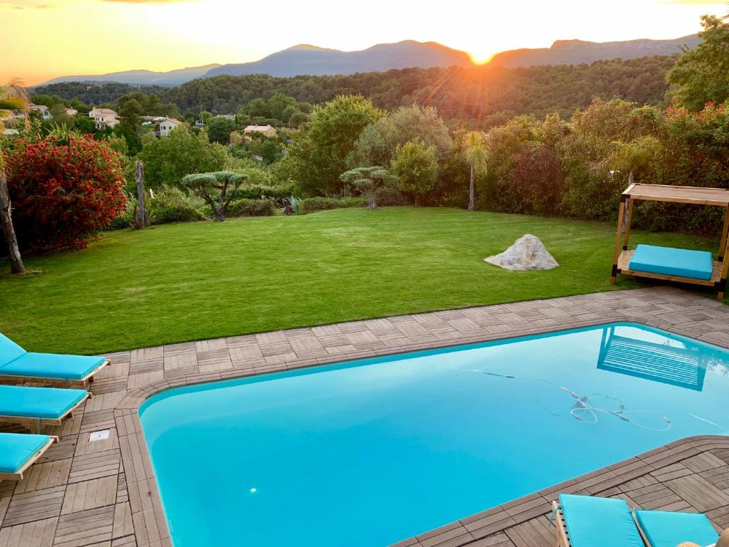 La piscine et la pelouse au coucher du soleil, face aux montagnes